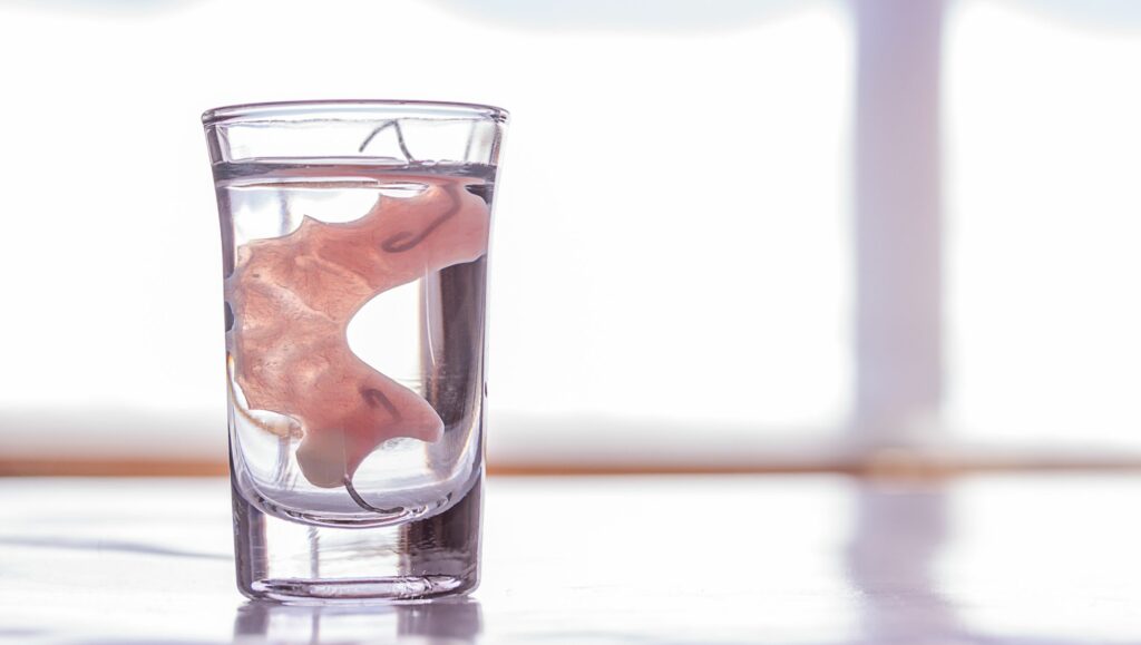 dentiera dentro un bicchiere d'acqua